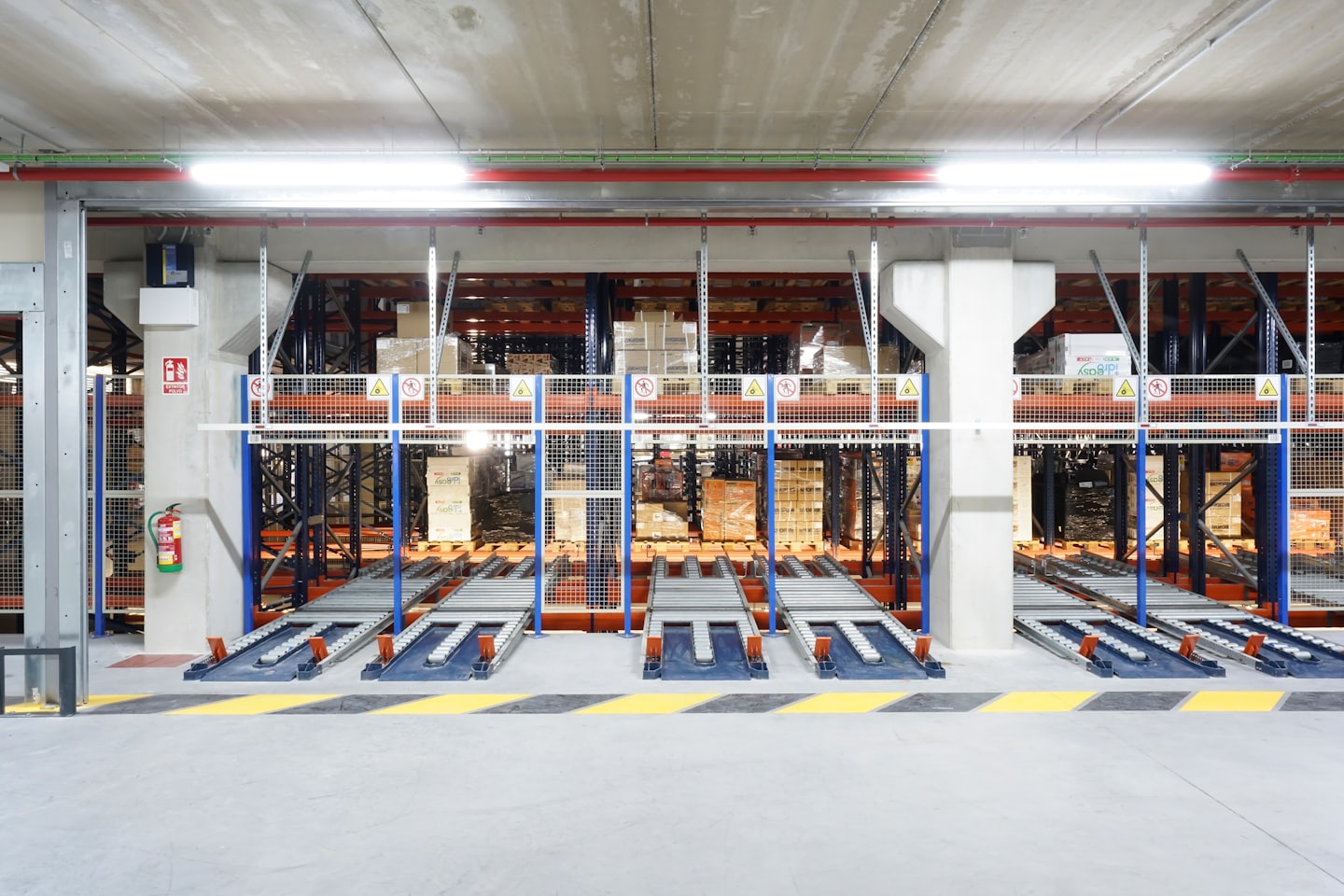 Almacén automatizado con estanterías de palets y sistemas de transporte.