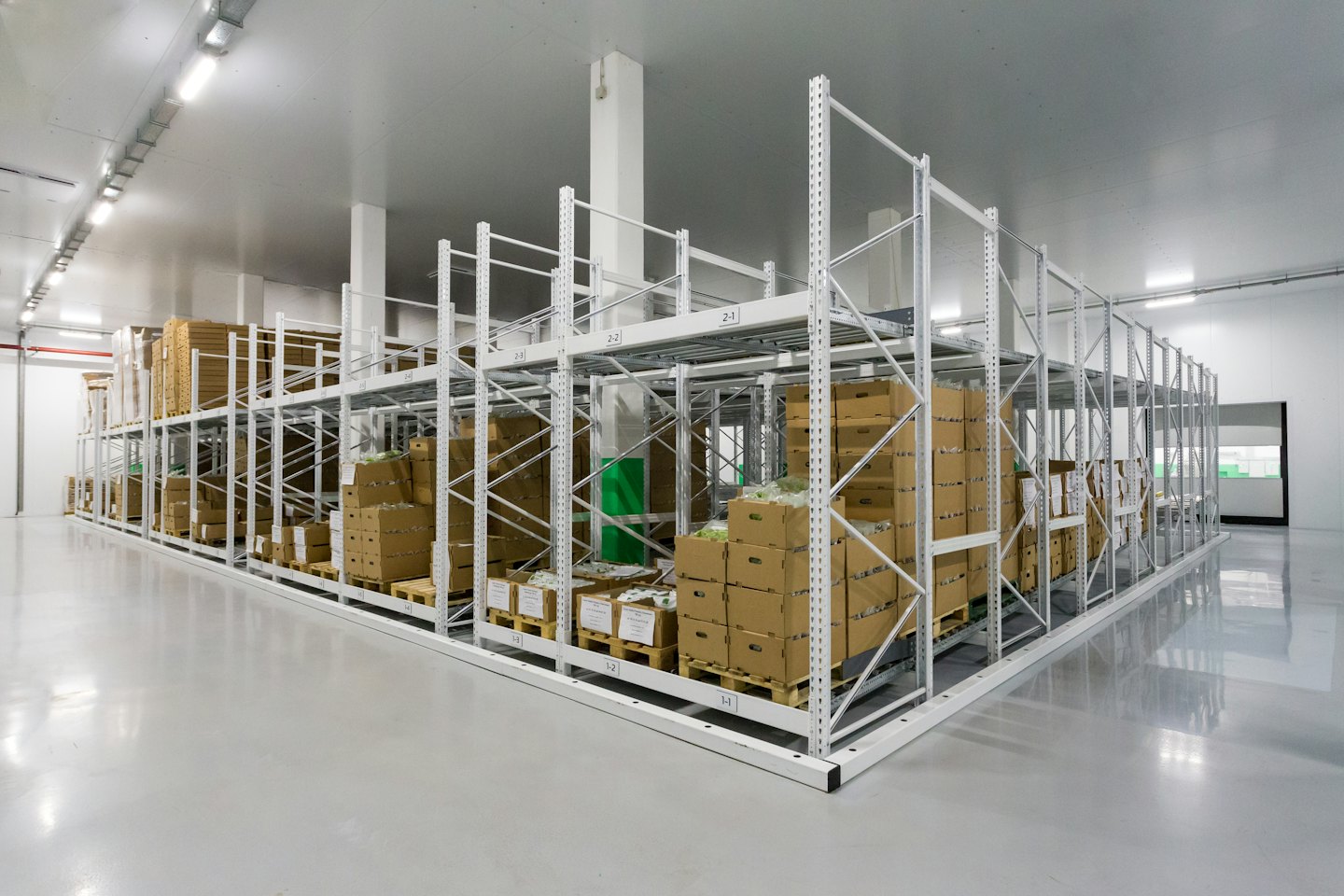 Estantes de almacén organizados llenos de cajas y palets.